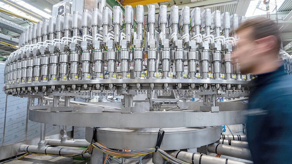 Ein Mitarbeiter geht an einer Abfüllanlage in der Produktion eines Maschinenbauunternehmens vorbei. Foto: dpa/Armin Weigel