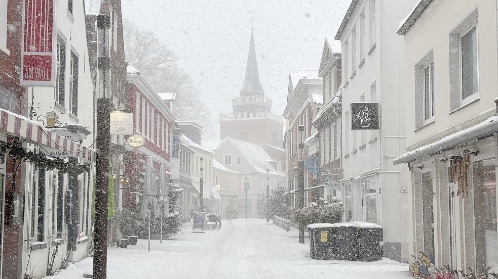Blick in die verschneite Burgstraße in Aurich, im Hintergrund das Auricher Wahrzeichen, der Lambertiturm. Foto: Lasse Paulsen