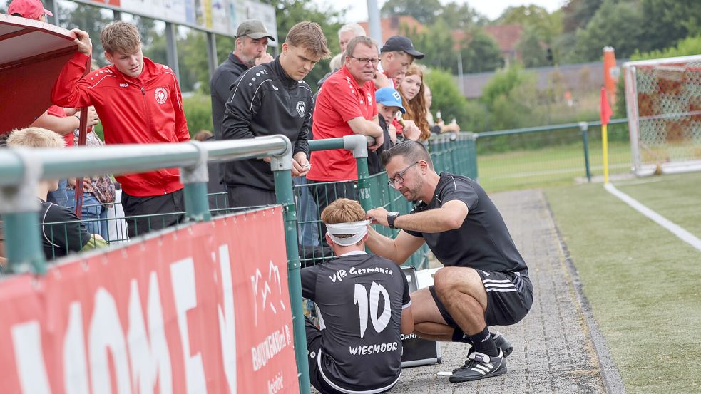 Coach Timo Pohling versorgt seinen verletzten Spieler Janek Swyter mit einem Kopfverband. Foto: Helmut Vortanz