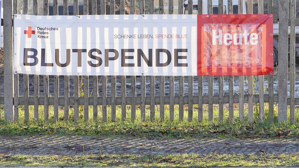 Aufruf zur Blutspende auf einem Werbebanner an einem Holzlattenzaun Foto: IMAGO/CHROMORANGE