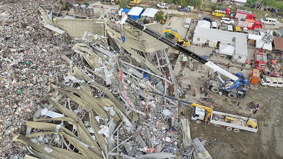 Die Einsatzkräfte suchen unter anderem mit einem Kran in den Abfall-Massen. Foto: Jacqueline Hernandez/AP/dpa