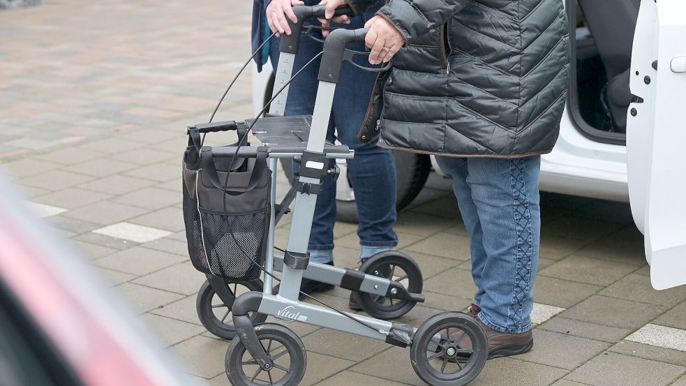 Eine Pflegedienstmitarbeiterin hilft einer pflegebedürftigen Seniorin beim Aussteigen aus einem Auto. Foto: DPA