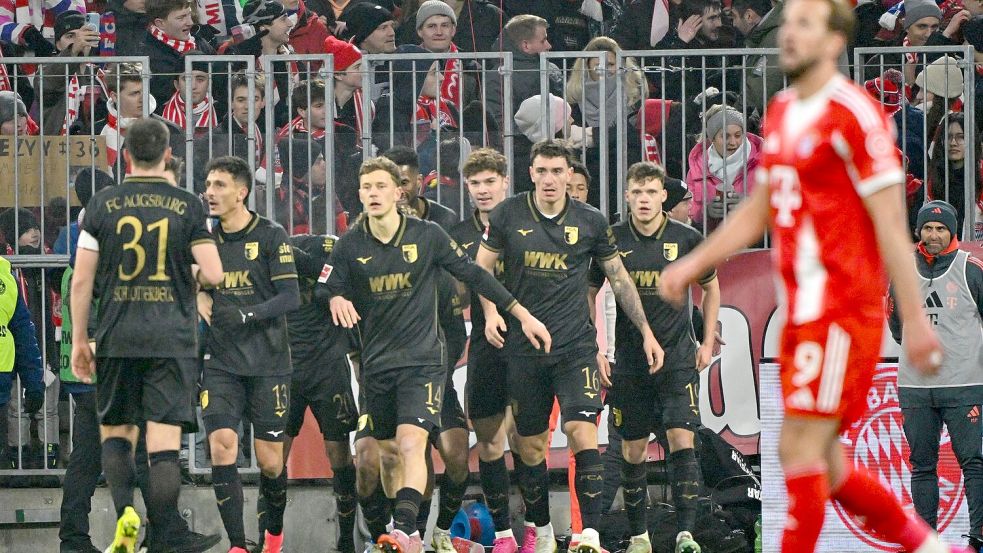 Freude beim FC Augsburg, Enttäuschung bei Harry Kane. Foto: Peter Kneffel/dpa