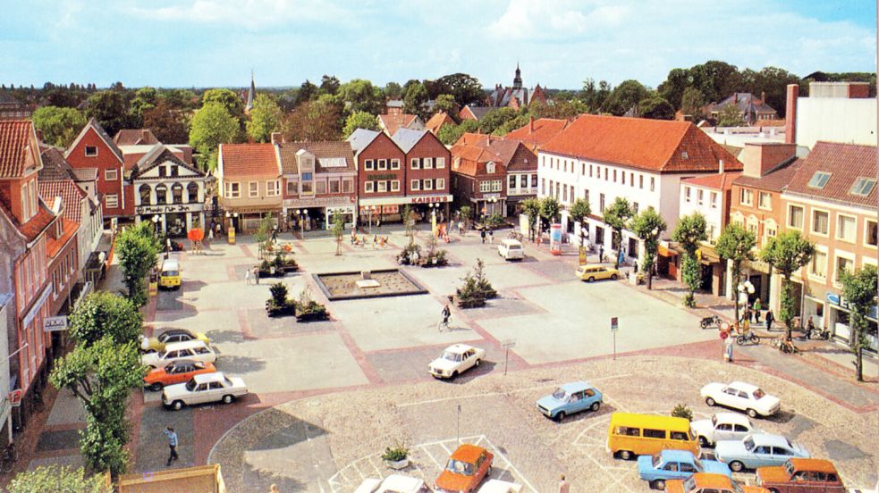 Das Zentrum der Innenstadt: Von 1976 bis zum Anfang der 1990er Jahre hatte Aurichs Marktplatz die vom Springbrunnen dominierte Optik. Charakteristisch für die damalige Zeit: Auf der Südseite flanierten die Besucher, auf der Nordseite parkten die Autos. Seit Anfang der 1990er-Jahre ziert den autofreien Marktplatz die Markthalle mit der darunterliegenden Tiefgarage. Foto: Archiv ON