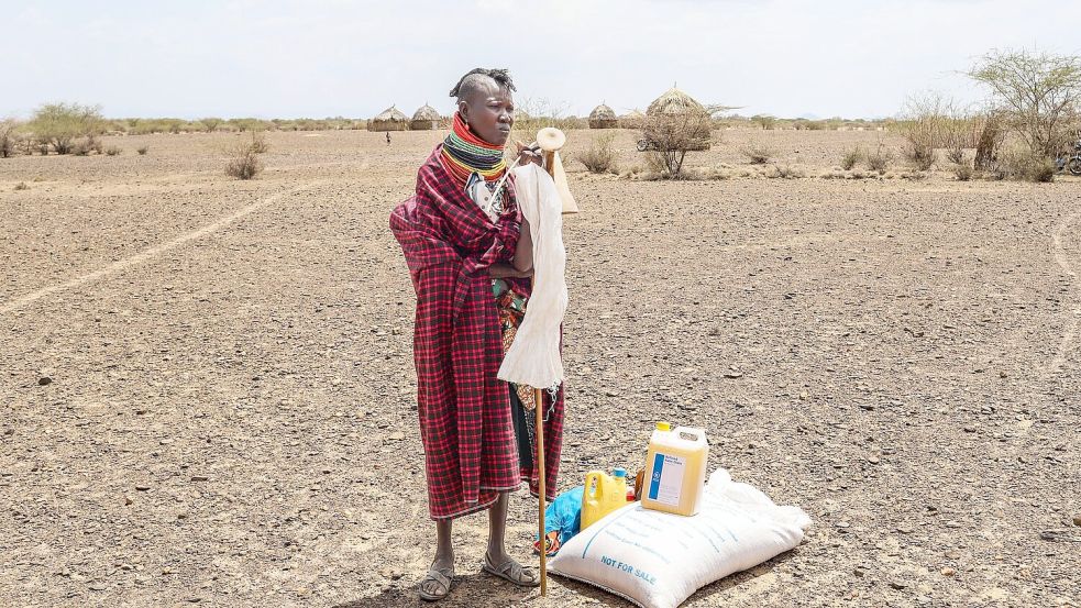 Eine Frau steht in Kenia neben einer Lebensmittelration des Welternährungsprogramms (WFP). Foto: Patrick Ngugi/AP/dpa