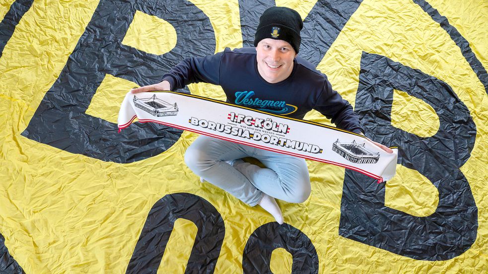 Christian Sanders aus Dornum ist großer BVB-Fan. Hier sitzt er auf einer selber angefertigten Riesen-Fahne. Foto: Klaus Ortgies