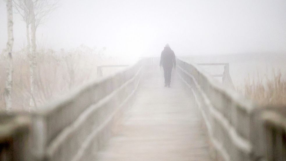 Eine Frau steht allein auf einem Steg – ein Symbolbild für die Einsamkeit auf dem Land. Foto: DPA/Thomas Warnack