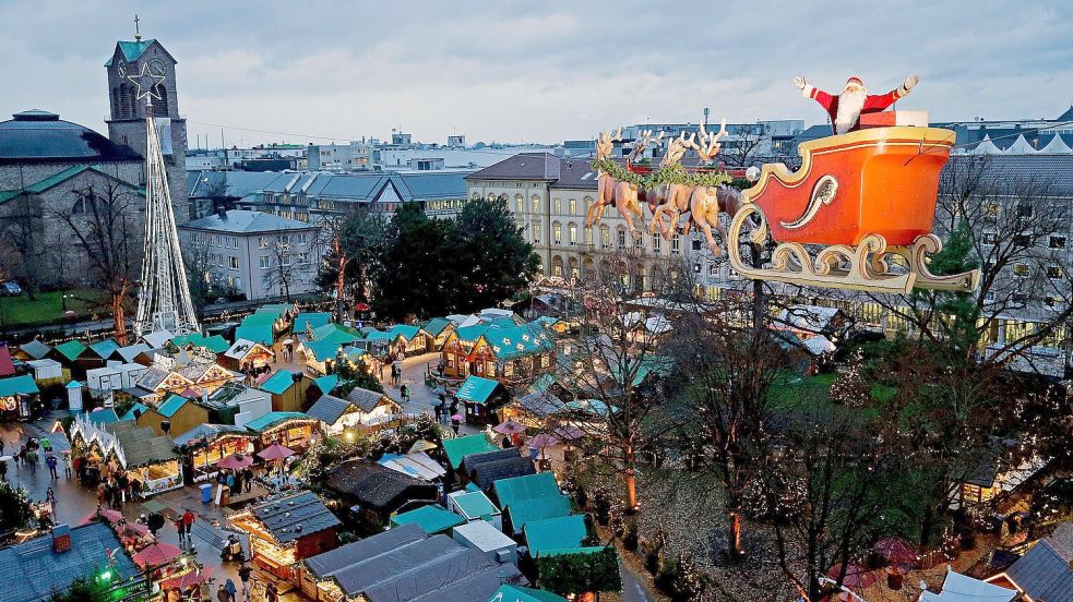 Hochseilartist Falko Traber posiert als „fliegender Weihnachtsmann“ verkleidet auf seinem als Rentierschlitten umgerüsteten Motorrad über dem Weihnachtsmarkt in Karlsruhe. Foto: DPA