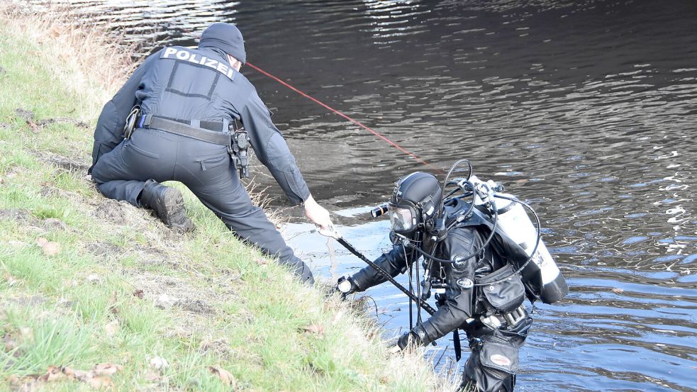 Ein Beamter hilft seinem Kollegen, aus dem Wasser zu steigen. Foto: Thomas Dirks