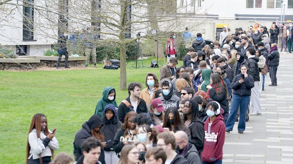 Menschen stehen an, um vorsorglich Antibiotika zu erhalten. Foto: Gareth Fuller