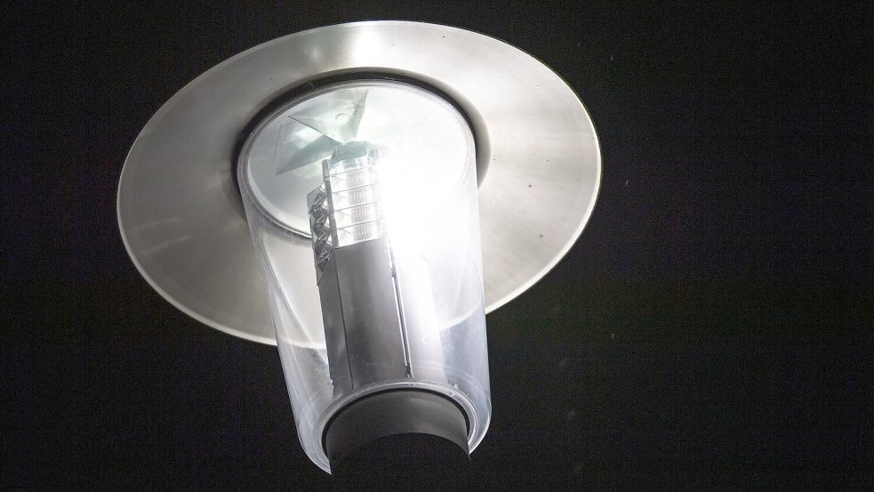 Eine leuchtende Straßenlaterne. Foto: DPA