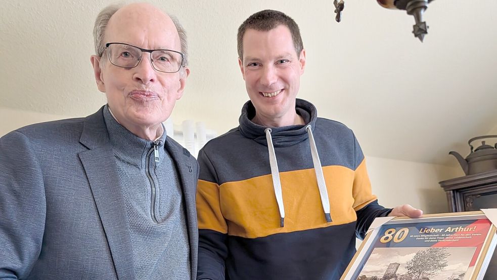 TuRa-Vorsitzender Peter Adena (rechts) überreichte Arthur Tuinmann eine Collage mit Fotos vom alten Sportplatz und seine Ehrenurkunde für 80 Jahre Vereinsmitgliedschaft. Foto: privat