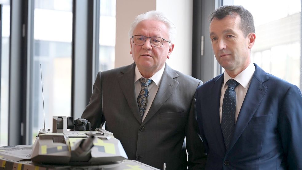 Papperger und Escribano bei einem Modell des Rheinmetall-Kampfpanzers Panther. Foto: Wolf von Dewitz/dpa