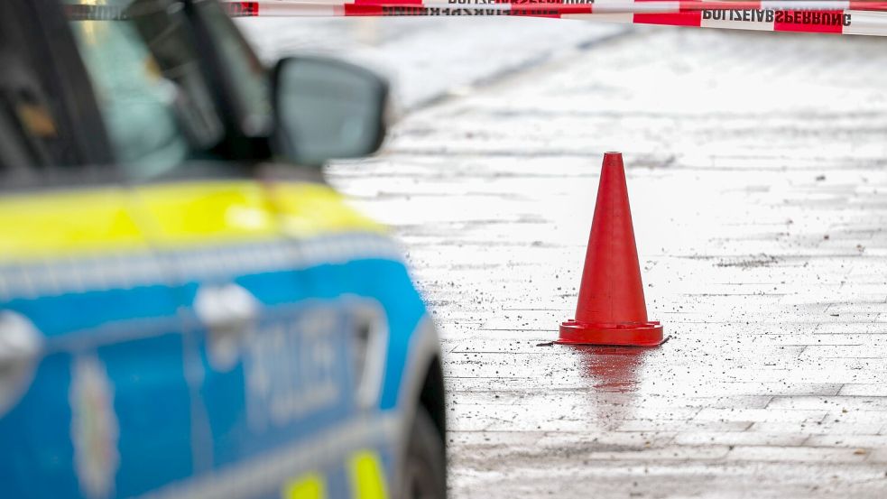 Polizeibeamte bewachen in einem Streifenwagen den Tatort. Foto: Christoph Reichwein