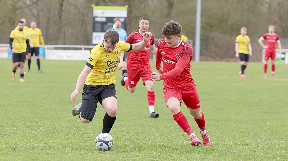 Weene und Westerende (rote Trikots) lieferten sich auf einem schwer bespielbaren Rasen einen kämpferischen Schlagabtausch. Foto: Wilfried Gronewold