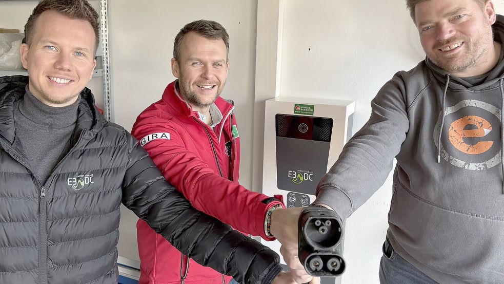 Ladestelle für zwei Richtungen: Stefan Bertels (rechts) kann an der Wallbox sein Auto laden, aber auch Strom aus der Autobatterie ins Hausnetz einspeisen. Links Tarik Guss von der Firma E3/DC, in der Mitte Elektromeister Stefan Essmann. Foto: Wilfried Hinrichs