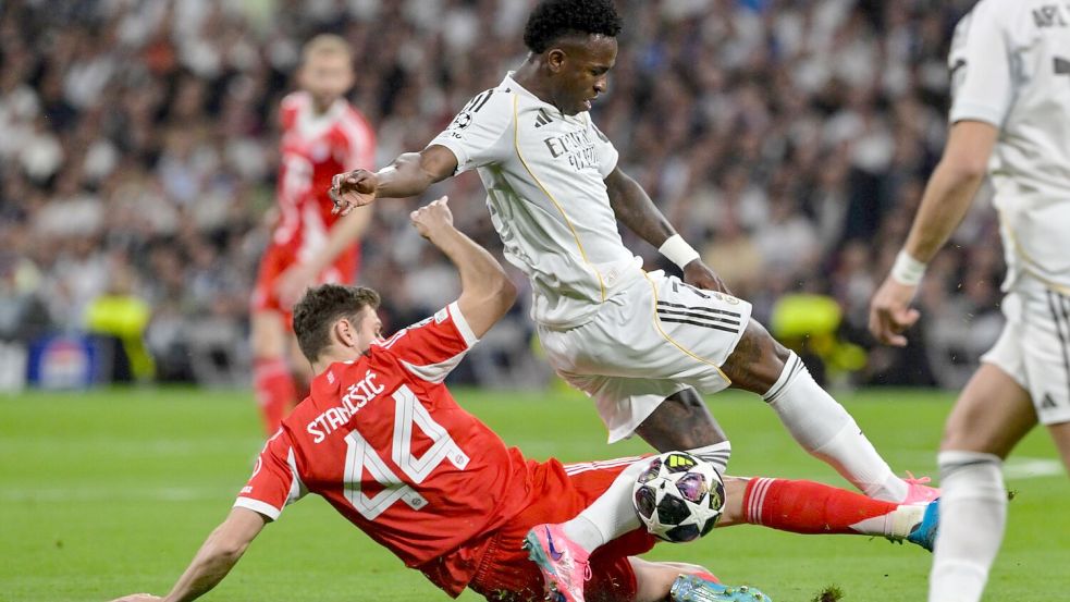 Josip Stanisic (l) bremst Reals Stürmerstar Vinícius Júnior.   Foto: Peter Kneffel