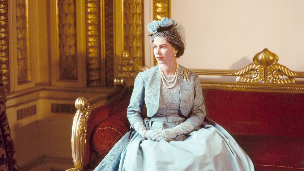 In hellblauem Kleid auf rot gepolstertem Sofa: das Bild der Ausstellung „Queen Elizabeth II: Her Life in Style“. Foto: Cecil Beaton Archive_Victoria and Albert Museum