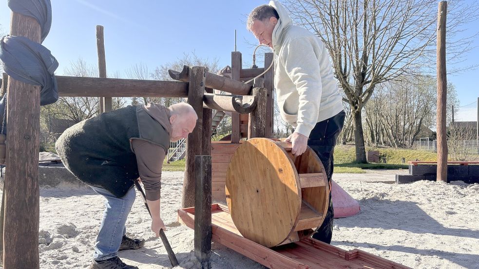 Achim Strzyzewski (links) und Manfred Post bauen in die Matschanlage die neuen Bauteile ein. Foto: Christin Wetzel