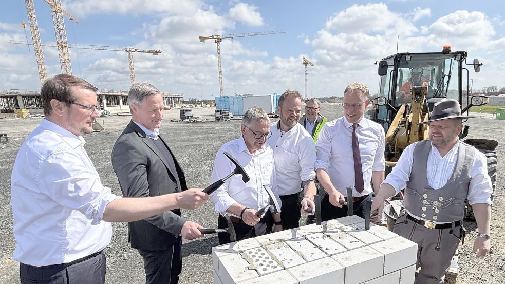 Halfen bei der Grundsteinlegung (von links): Klinik-Aufsichtsratsvorsitzender und Emder Oberbürgermeister Tim Kruithoff, Klinik-Geschäftsführer Dirk Balster, Landrat Olaf Meinen, die Landtagsabgeordneten Matthias Arends (Emden/Norden) und Wiard Siebels (Aurich) sowie Polier Roland Bensch. Im Hintergrund steht Projektleiter Michael Diekhans. Foto: Aiko Recke