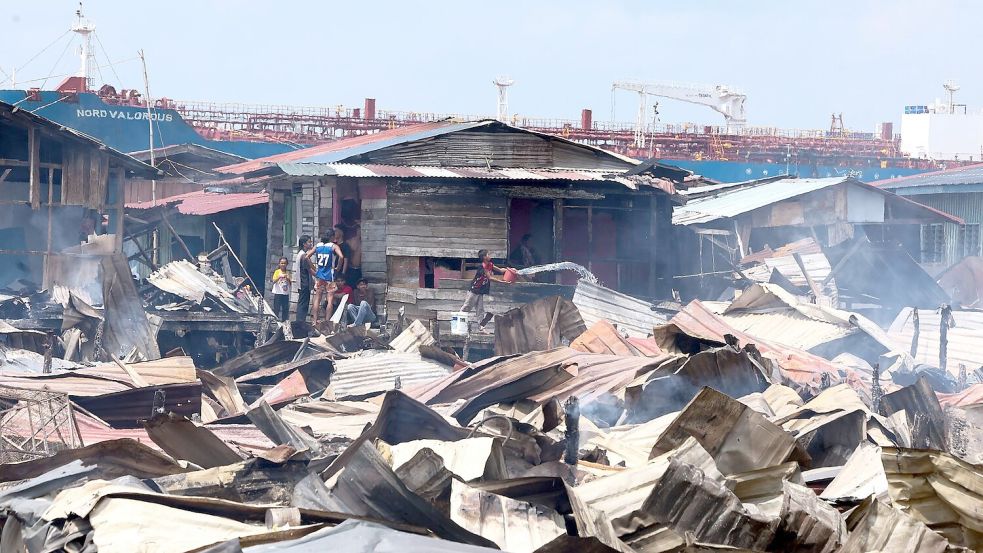 Die Löscharbeiten wurden nach Angaben von Einsatzkräften durch enge Zufahrten, starken Wind und eingeschränkten Zugang zu Wasser bei Ebbe erschwert. Foto: Bernama/Handout/XinHua/dpa