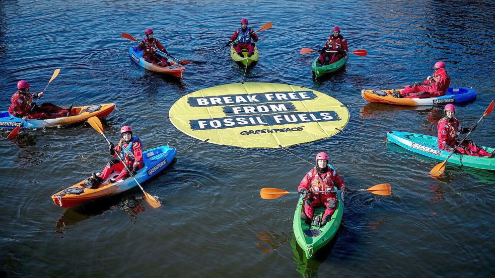 Greenpeace fordert bei einer Aktion am Veranstaltungsort die Abkehr von fossilen Energien. Foto: Kay Nietfeld/dpa