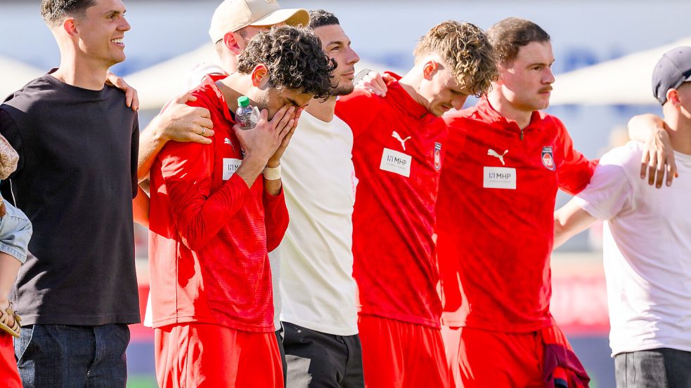 „Goldjunge“ Eren Dinkci (2.v.l.) wurde nach dem Spiel von der Heidenheimer Kurve gefeiert – und war sichtlich emotional berührt. Foto: DPA/Tom Weller