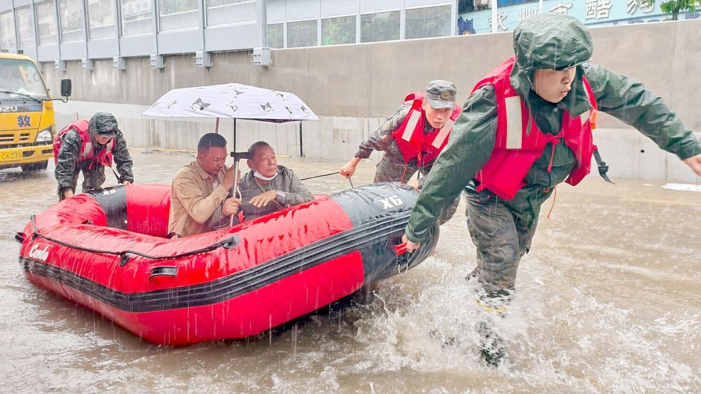 Retter helfen mit Schlauchbooten nach den starken Regenfällen in Qinzhou. Foto: Ao Shuaichang/X/XinHua/dpa