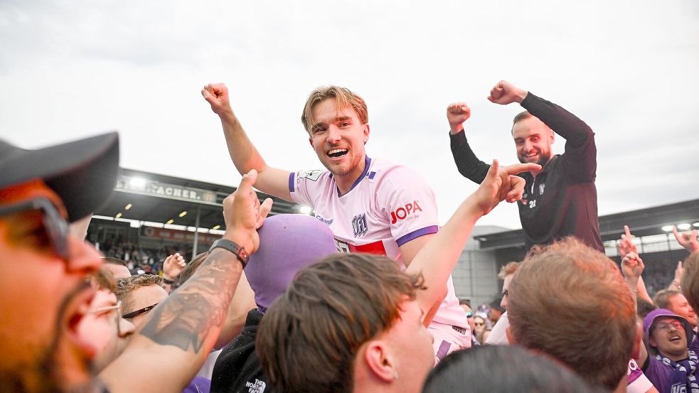 Auf Händen getragen: Die Aufstiegshelden Lars Kehl (Mitte) und David Kopacz werden von den Fans des VfL Osnabrück gefeiert. Foto: Michael Titgemeyer