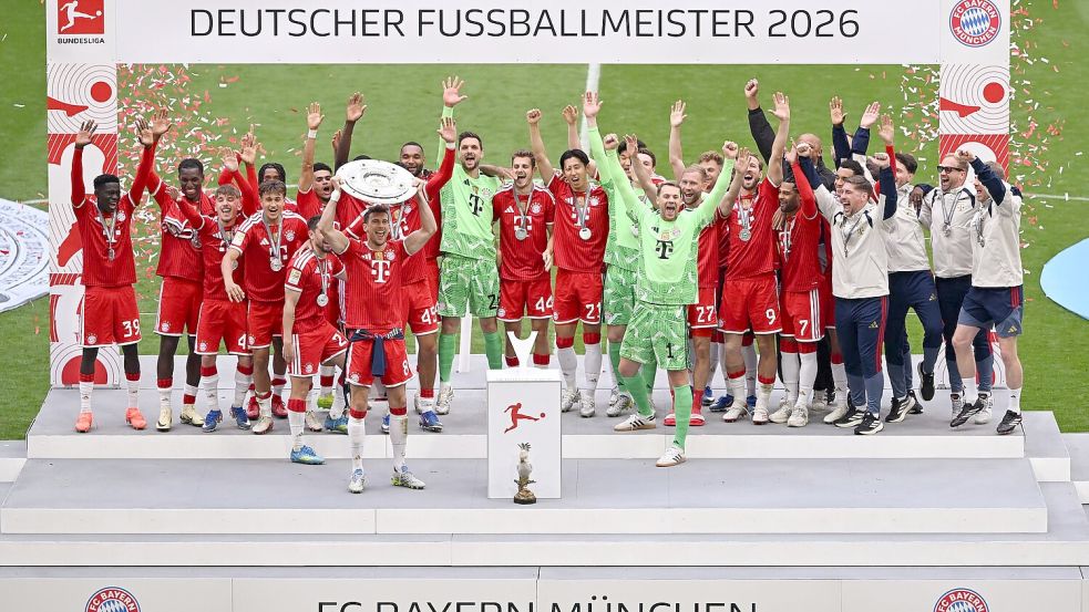 Die Bayern feiern mit der Meisterschale, die Leon Goretzka in Händen hält. Foto: Sven Hoppe