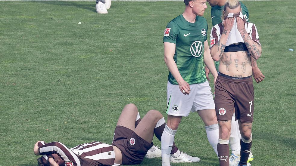 Jackson Irvine (FC St. Pauli) zieht sich das Trikot vors Gesicht: Der FC St. Pauli ist abgestiegen. Foto: IMAGO/Susanne Hübner