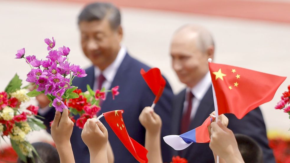 Mit Blumen und Fähnchen empfingen chinesische Kinder den Gast aus Moskau. Foto: Maxim Shemetov