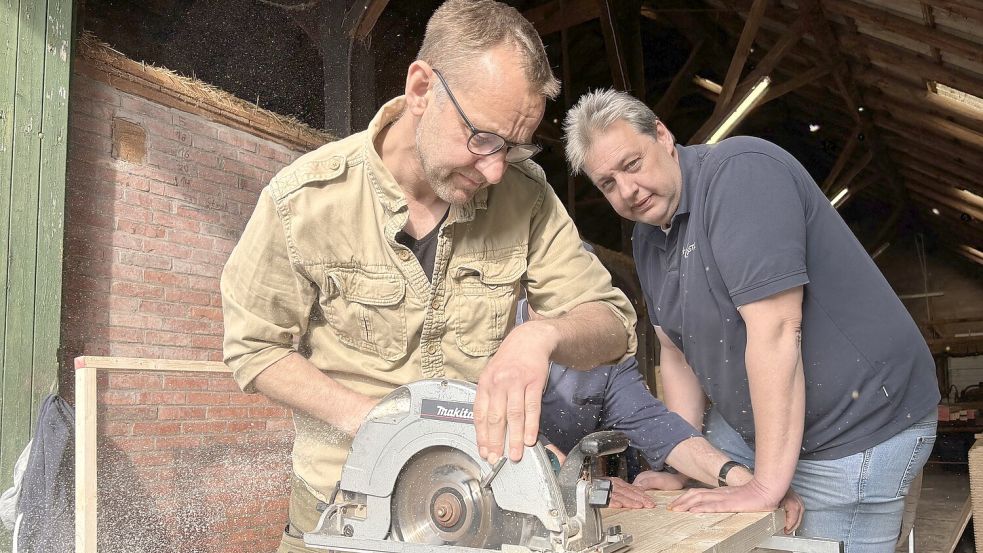 Hans Otto de Vries (links) und Helmut Franken sägen mehrere Holzlatten zurecht. Foto: Christin Wetzel