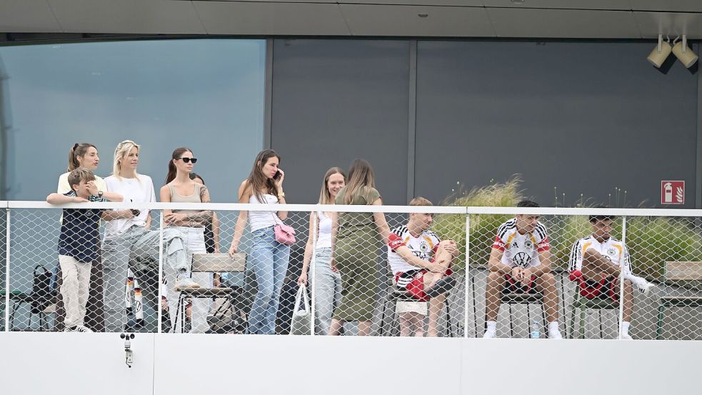 Einige Spielerfrauen und die Frau des Bundestrainers (l) beobachten von einem Balkon das Trainingsspiel der Reservisten auf dem DFB-Campus. Foto: Federico Gambarini/dpa