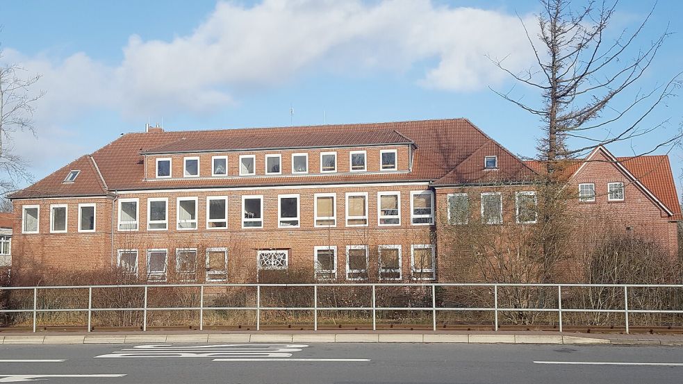 Im Herbst, wenn Bäume und Büsche kahl sind, ist das alte Schulgebäude von der Bundesstraße aus gut zu erkennen. Am rechten Bildrand ist das Gebäude aus dem Jahr 1996 zu sehen, das die Gemeinde gerne dem Landkreis abkaufen würde. Foto: Holger Janssen