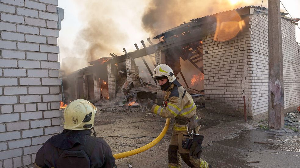 Rettungskräfte löschen ein Feuer in einer Kiewer Autowerkstatt, die durch einen russischen Angriff beschädigt wurde. Foto: Evgeniy Maloletka