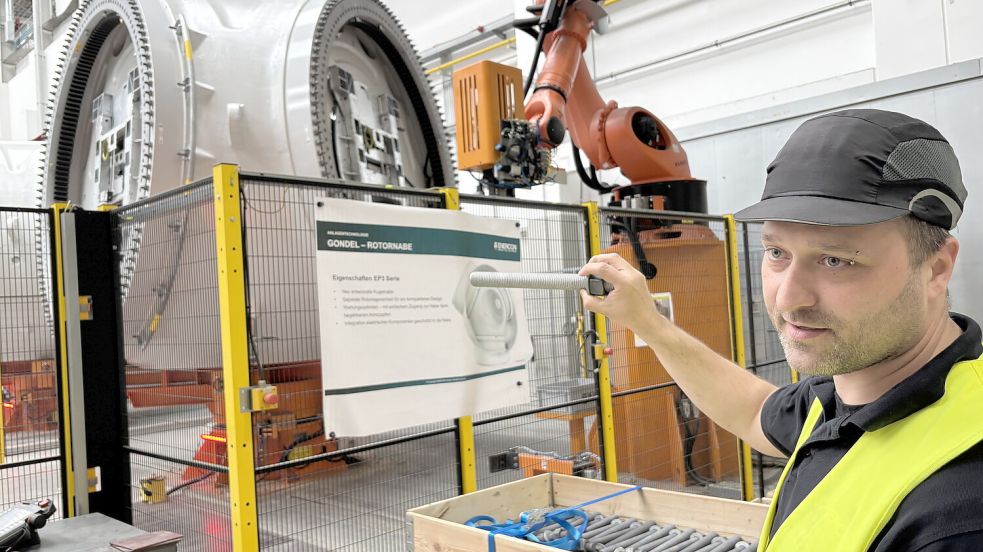 Insgesamt 360 Verschraubungen an der Rotornabe erledigen seit einiger Zeit im Auricher Werk Roboter. Produktionsleiter Daniel Wienekamp zeigt, wie groß die Schrauben sind. Foto: Aiko Recke