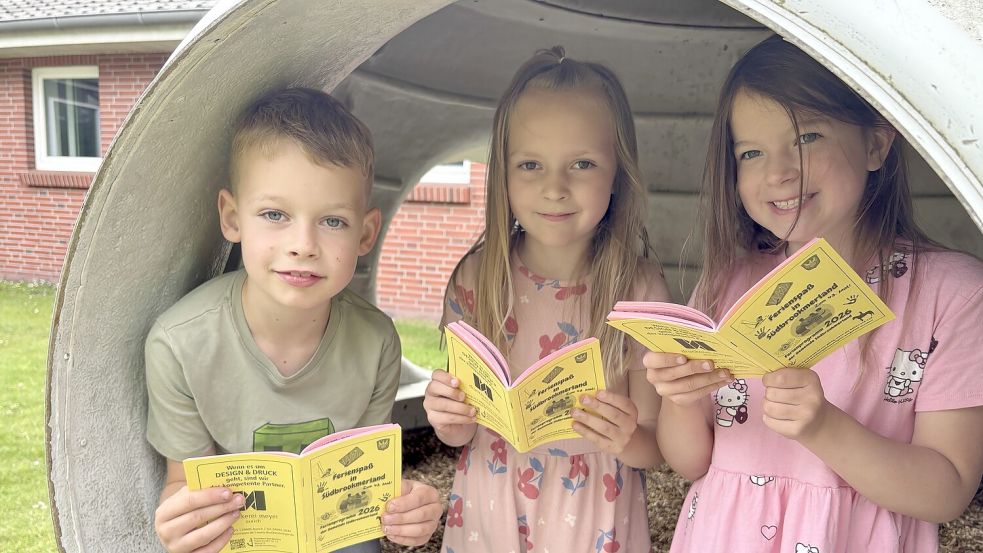 Ben Doden (von links), Mara Linnemann und Lena Steinhorst aus der Klasse 1b der Grundschule Victorbur haben bereits im neuen Ferienpass gestöbert. Foto: Holger Janssen