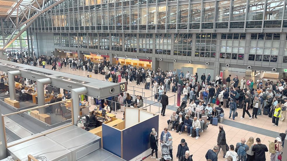 Zahlreiche Menschen stehen im Terminal des Hamburger Flughafens. Foto: Frank Molter