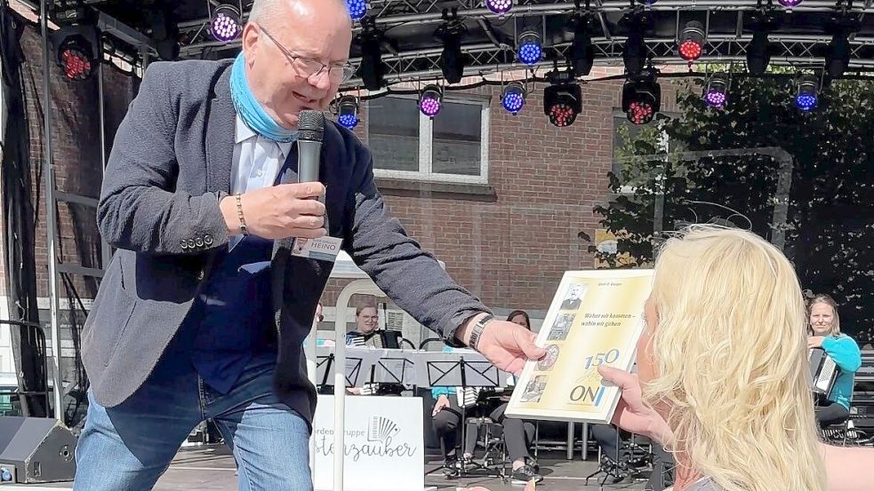 Moderator Heino Krüger überreicht die ersteigerten Tauschgüter. Foto: Udo Hippen
