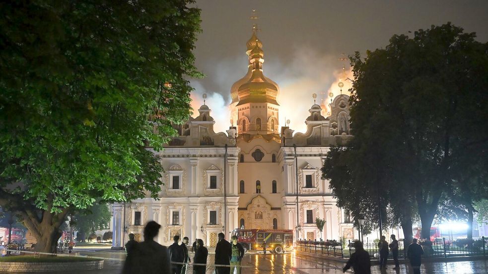 Flammen züngeln aus dem Dach unter den vergoldeten Kuppeln der Mariä-Entschlafens-Kathedrale. Foto: Danylo Antoniuk/AP/dpa