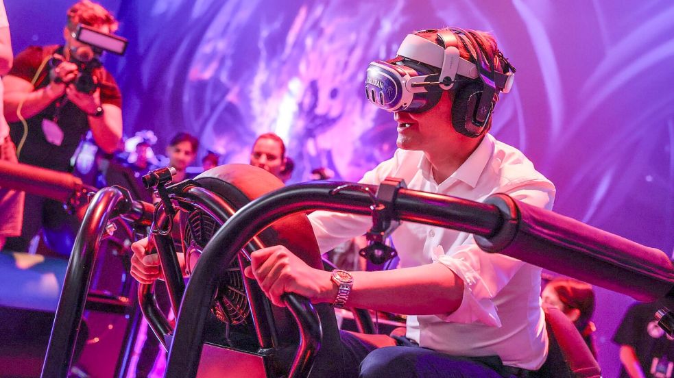 Ein wilder Ritt bei der Gamescom 2024: Hendrik Wüst auf einem „Drachen“, genauer gesagt mit virtueller Brille auf einem schwankenden Gestell. Foto: Oliver Berg