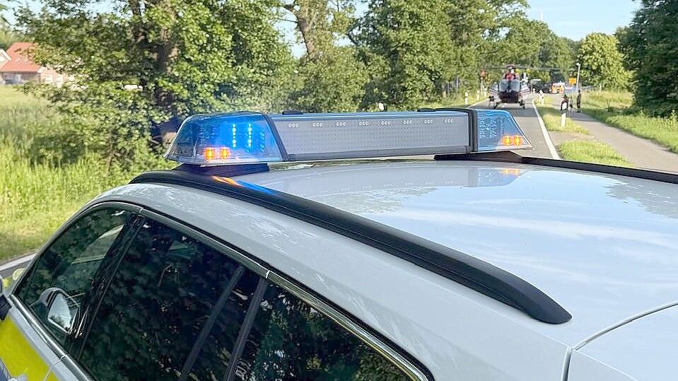 Die Polizei hat die Langholter Straße in Ostrhauderfehn gesperrt. Zwischenzeitlich ist ein Rettungshubschrauber (im Hintergrund) gelandet. Foto: Horst Kruse