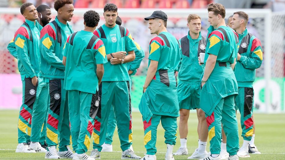 Die deutschen Spieler auf dem Stadionrasen nach der Ankunft. Foto: Jan Woitas/dpa