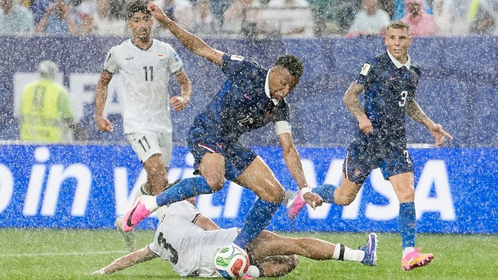 Stürmerstar im Regen: Frankreichs Kylian Mbappé im Zweikampf mit dem Iraker Hussein Ali. Foto: Matt Slocum