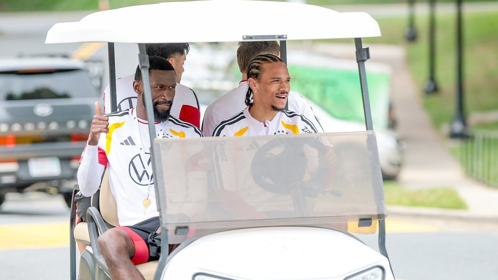 Zwei Umstrittene, die sich bestens verstehen: Beifahrer Antonio Rüdiger und Fahrer Leroy Sané (r) im Golfcart auf dem Weg zum Trainingsplatz. (Archivbild) Foto: Jan Woitas