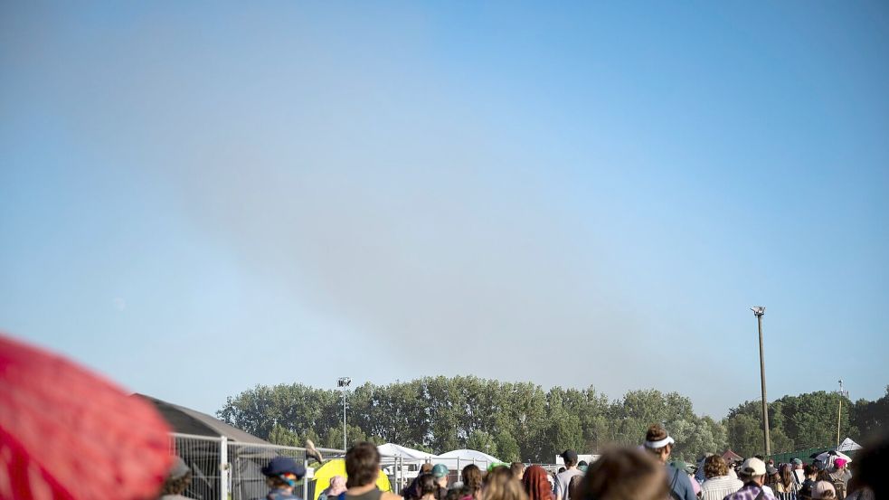 Eine Rauchsäule steigt unweit des Festivalgeländes in die Luft. Foto: Philip Dulian