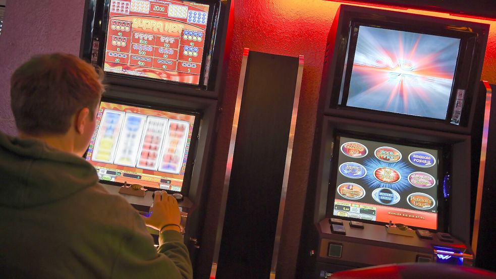 Ein junger Mann spielt in einem Casino an einem Spielautomaten. Foto: DPA