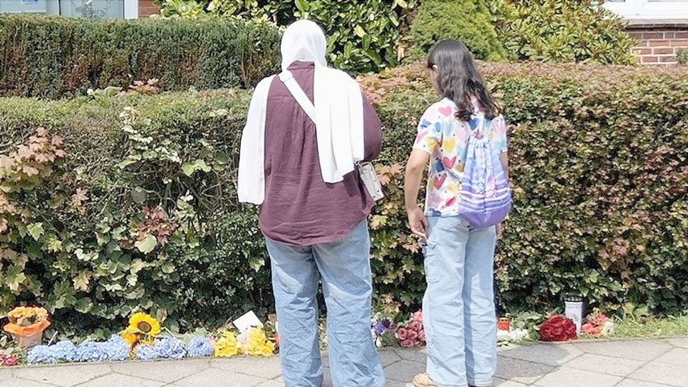 Blumen und Kerzen stehen und liegen am Tatort. Foto: Jörn Hüneke/dpa
