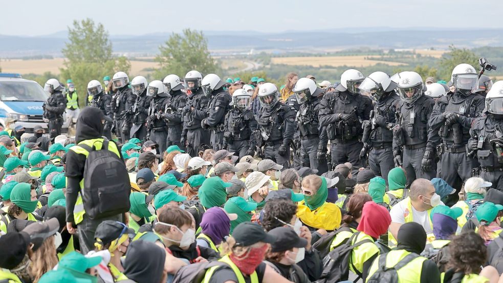 Eine Sitzblockade auf der Autobahn 71 - Polizisten umringen die Demonstranten. Foto: Michael Reichel/dpa